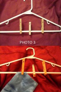 Once you have labeled the clothespins, clip them on the hanger. Finally, attach the cut fabric pieces to their corresponding labeled clothespin by clipping the fabric to the hanger.