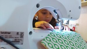 Spend some time demonstrating how fabric goes through the machine and how the needle is in constant motion when the foot pedal engaged.