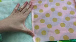 Here I folded the cotton fabric seam over the minky fabric and then placed a scrap of fabric over both.