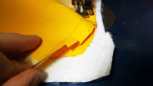 Cut snips into the fabric as you go around the corners.