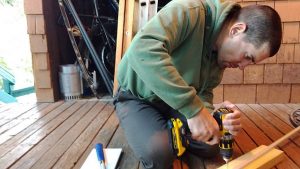 Drilling holes in the side of the board that didn’t have the track, right into a stud in the ceiling.